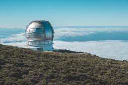 Ein Teleskop auf La Palma mit den Wolken im Hintergrund